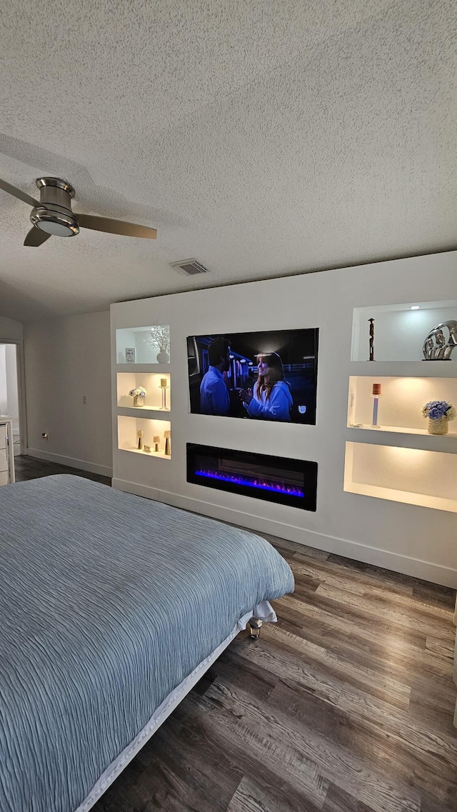 bedroom with a textured ceiling, ceiling fan, and wood-type flooring