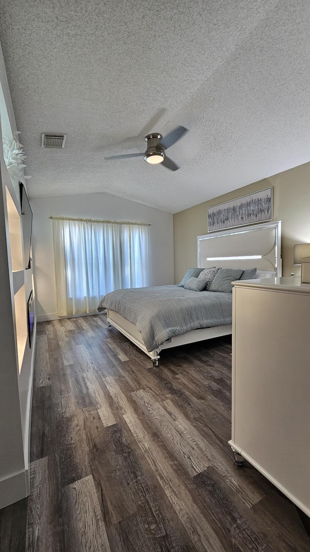 unfurnished bedroom featuring ceiling fan, dark wood-type flooring, vaulted ceiling, and a textured ceiling