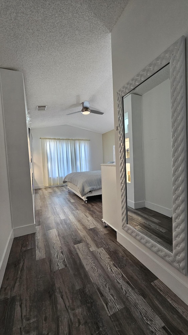 unfurnished bedroom with vaulted ceiling, a textured ceiling, ceiling fan, and a closet