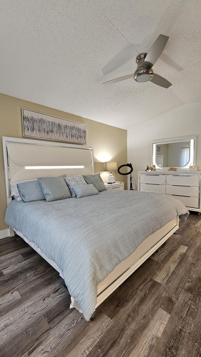 bedroom with lofted ceiling, a textured ceiling, ceiling fan, and dark hardwood / wood-style flooring