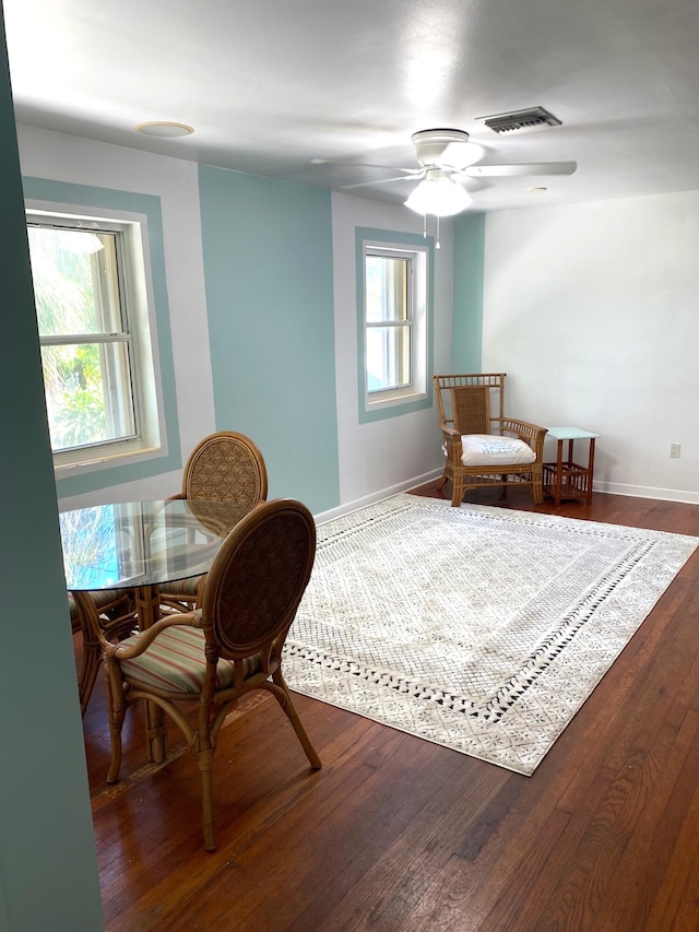 living area featuring ceiling fan and dark hardwood / wood-style flooring