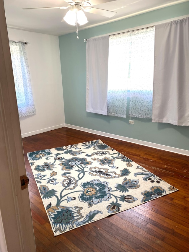 empty room with dark wood-type flooring and ceiling fan