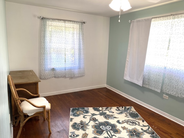 living area with ceiling fan and dark hardwood / wood-style floors