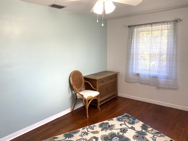 living area featuring dark wood-type flooring and ceiling fan