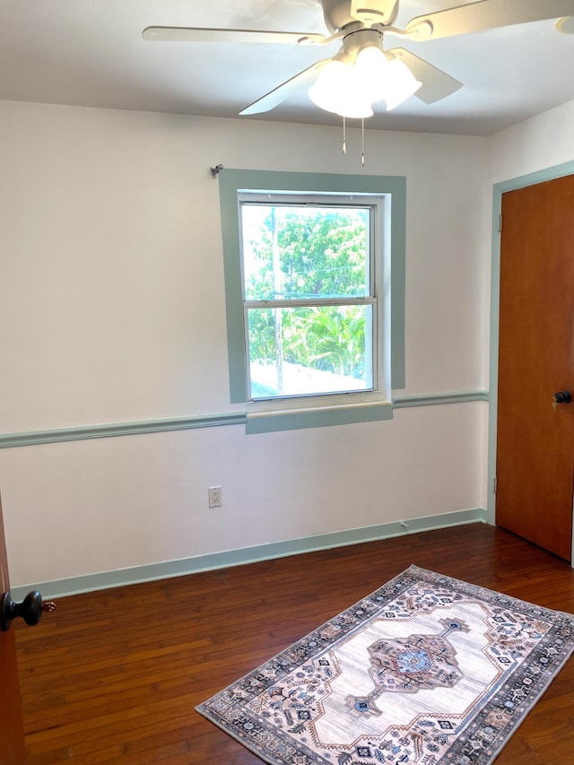 empty room featuring ceiling fan and dark hardwood / wood-style flooring