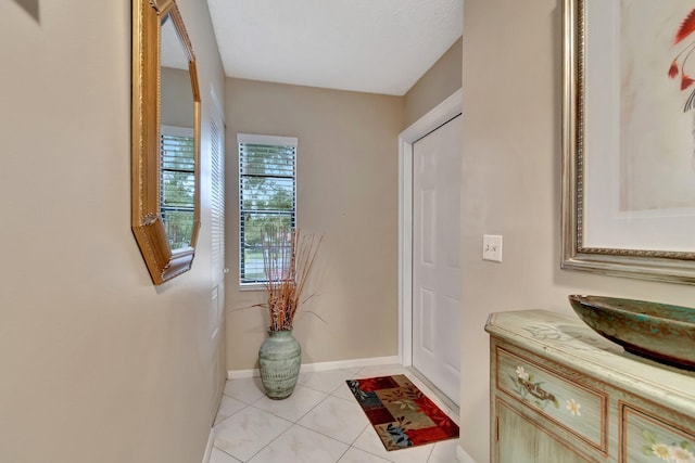 doorway to outside featuring sink and light tile patterned flooring