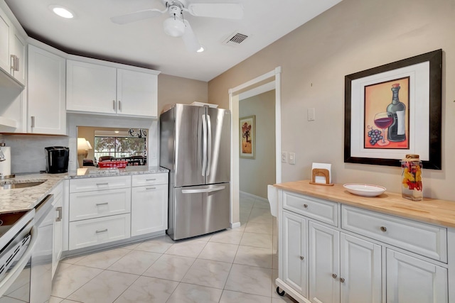 kitchen featuring ceiling fan, white cabinets, stainless steel fridge, and light tile patterned flooring