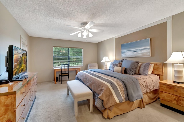 carpeted bedroom featuring ceiling fan and a textured ceiling