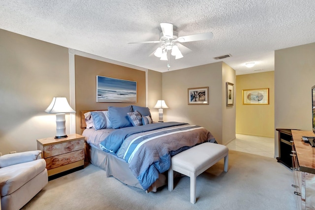 carpeted bedroom with ceiling fan and a textured ceiling