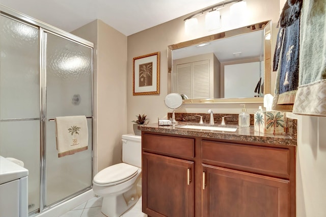 bathroom with toilet, vanity, a shower with door, and tile patterned floors