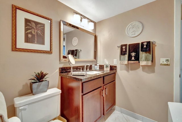 bathroom with toilet, vanity, and tile patterned flooring