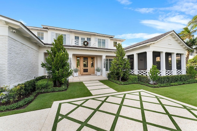 view of front of property featuring a balcony and a front lawn