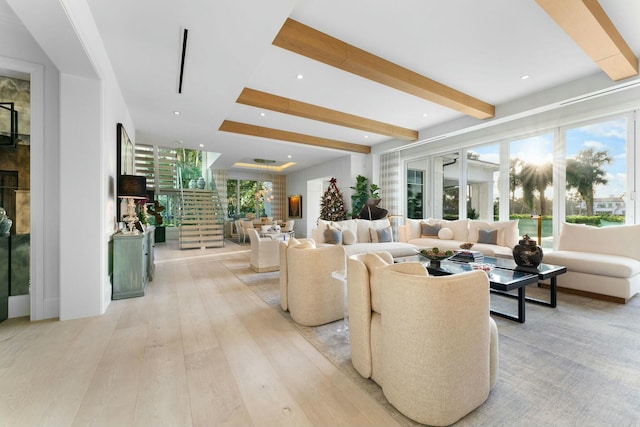 living room featuring beamed ceiling, light hardwood / wood-style floors, and a wealth of natural light