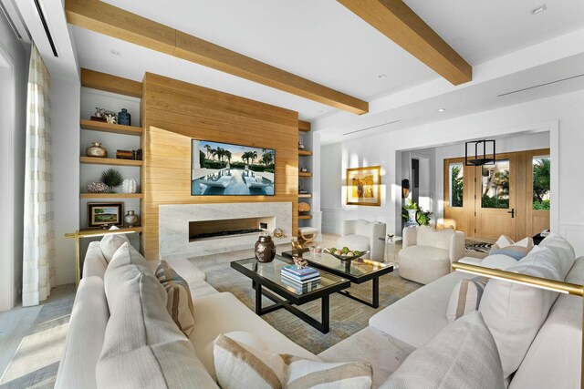 living room featuring beamed ceiling, light hardwood / wood-style floors, and a wealth of natural light