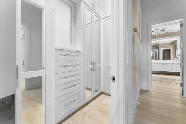 bathroom with vanity, ornamental molding, a tray ceiling, and a notable chandelier