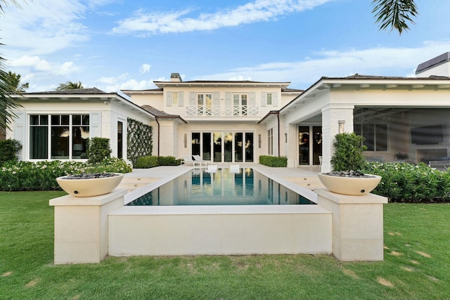 rear view of house with a yard and a patio