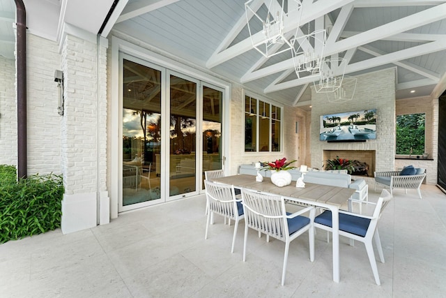 sunroom with exterior fireplace and vaulted ceiling with beams