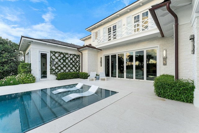 back of property with a balcony and a patio area