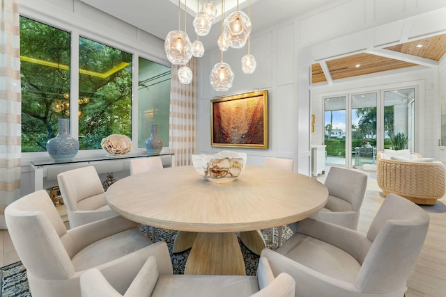 dining space featuring light hardwood / wood-style flooring and wooden ceiling