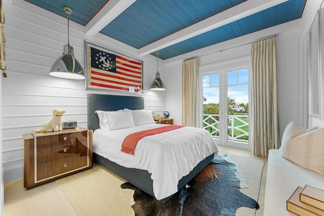 bedroom featuring wood-type flooring, access to outside, and beam ceiling