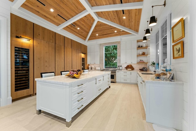 kitchen featuring beverage cooler, wooden ceiling, a kitchen island, white cabinetry, and decorative light fixtures