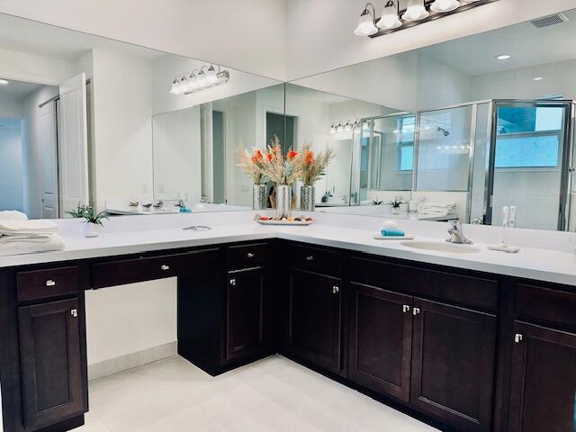 bathroom with vanity and a shower with door