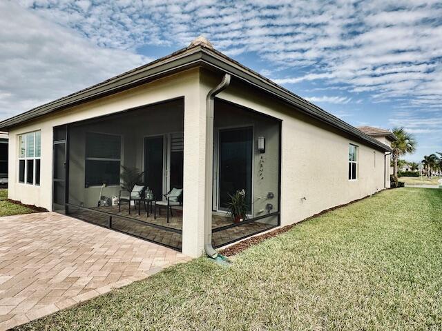 back of house featuring a yard, a sunroom, and a patio