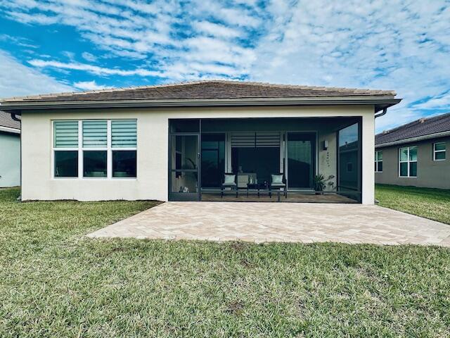 rear view of property with a patio area and a lawn