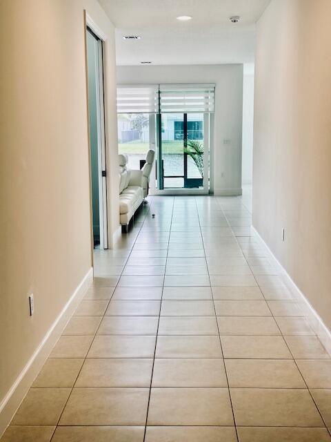 hall with light tile patterned floors