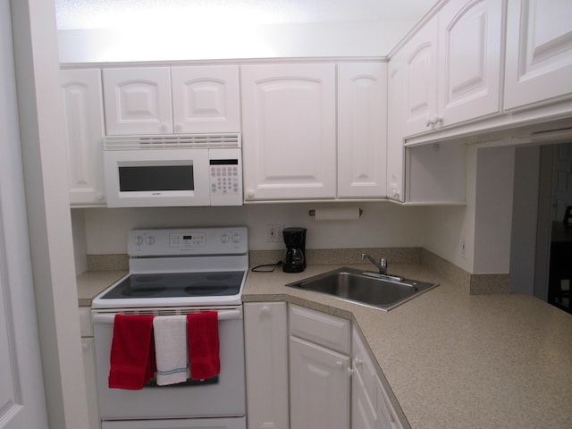 kitchen with sink, white appliances, and white cabinetry