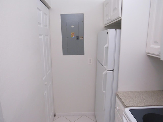 laundry area featuring electric panel and light tile patterned flooring