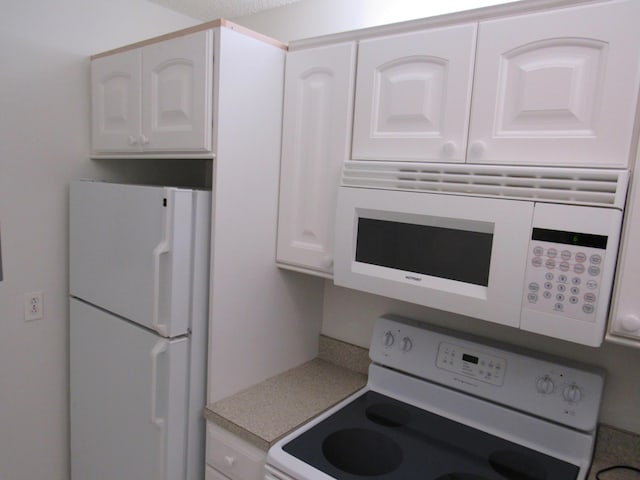 kitchen featuring white appliances and white cabinetry