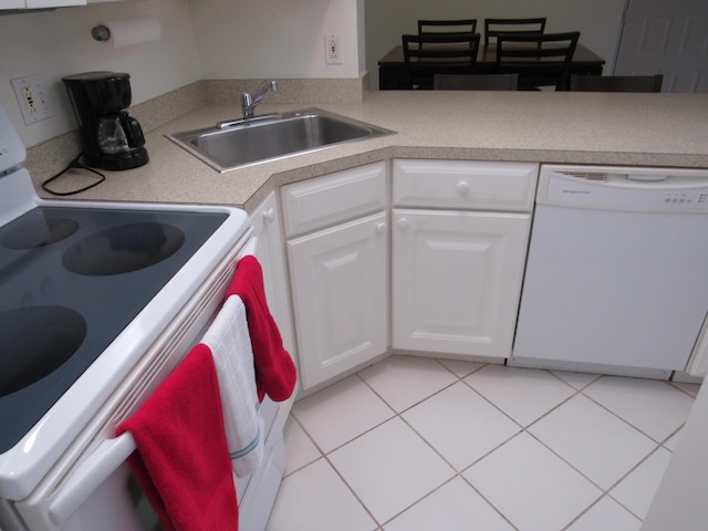 kitchen featuring white appliances, white cabinets, sink, and light tile patterned floors