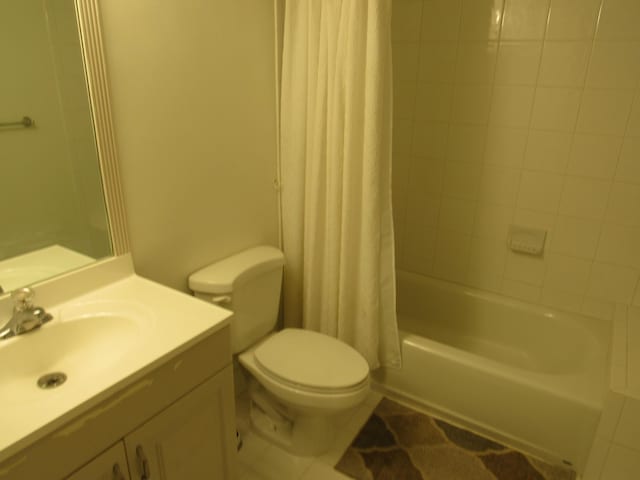 full bathroom with toilet, tile patterned flooring, shower / tub combo with curtain, and vanity