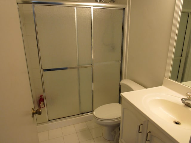 bathroom featuring vanity, tile patterned floors, a shower with shower door, and toilet