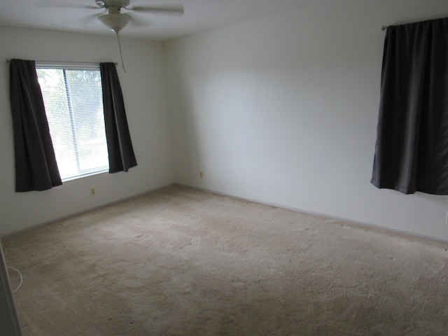 unfurnished room featuring ceiling fan and light colored carpet