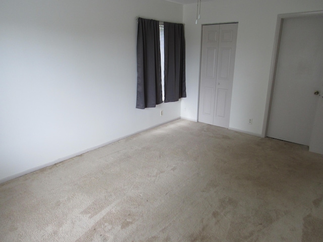 unfurnished bedroom featuring light carpet