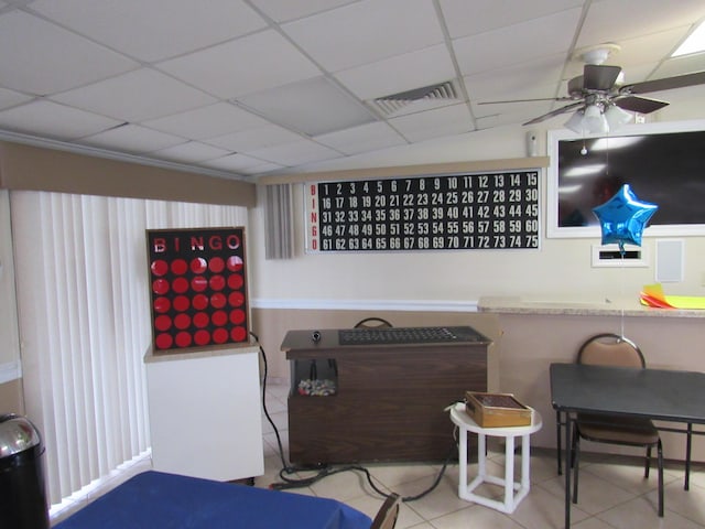 interior space featuring a drop ceiling, ceiling fan, and light tile patterned floors