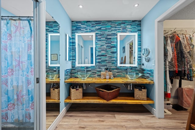 bathroom featuring decorative backsplash, hardwood / wood-style flooring, and vanity