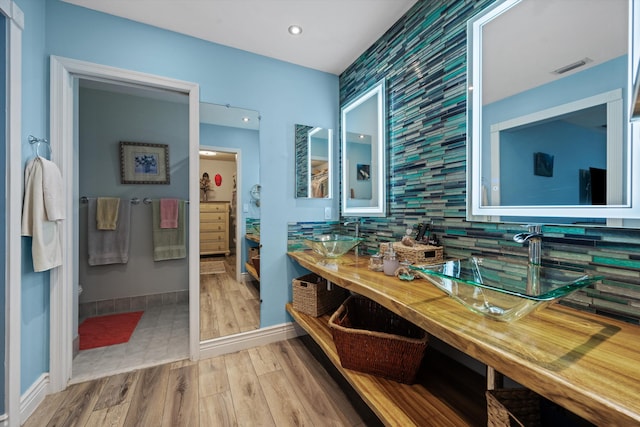 bathroom featuring vanity, wood-type flooring, and backsplash