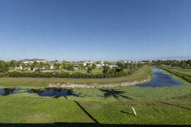 view of property's community with a water view and a yard