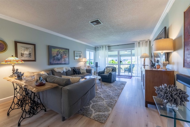 living room featuring a textured ceiling, crown molding, and light wood-type flooring