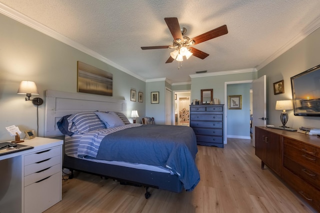 bedroom with ceiling fan, light hardwood / wood-style floors, a textured ceiling, and crown molding