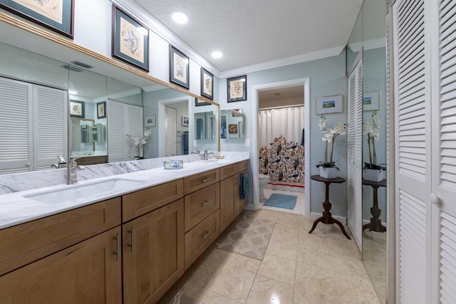 bathroom featuring a textured ceiling, tile patterned flooring, vanity, toilet, and crown molding