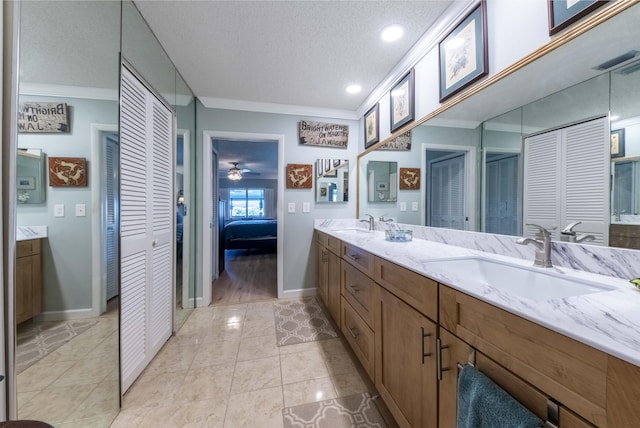 bathroom featuring a textured ceiling, vanity, ornamental molding, and tile patterned flooring