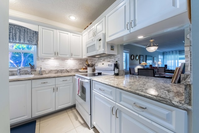 kitchen with white cabinets, sink, white appliances, and light tile patterned flooring