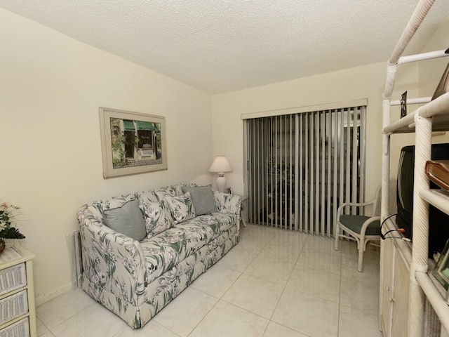 tiled living room featuring a textured ceiling