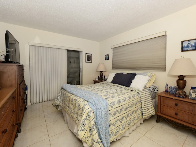 bedroom with a textured ceiling and light tile patterned floors