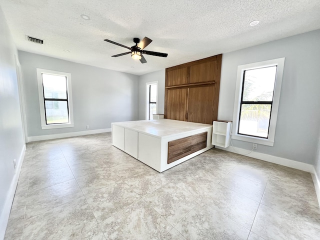 unfurnished bedroom featuring ceiling fan and a textured ceiling