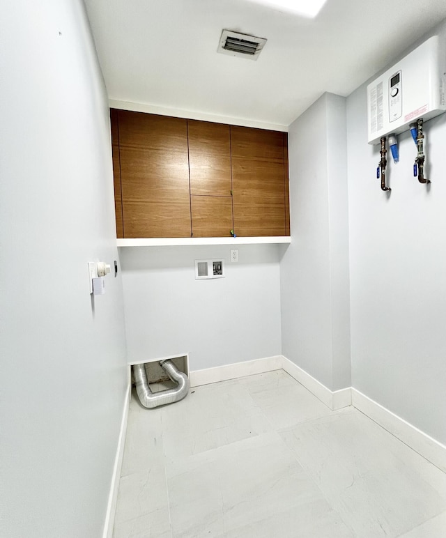 clothes washing area featuring water heater, hookup for a washing machine, and cabinets